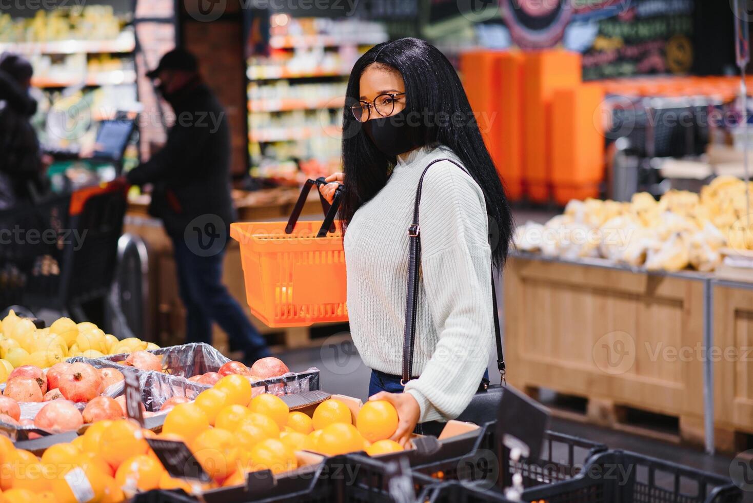 afrikanisch Frau tragen Einweg medizinisch Maske. Einkaufen im Supermarkt während Coronavirus Pandämie Ausbruch. Epidemie Zeit foto