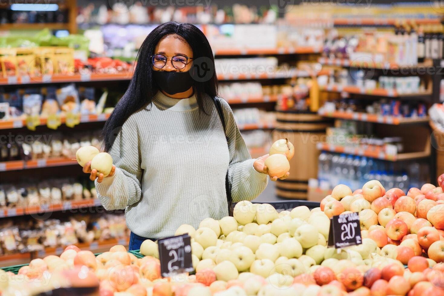 afrikanisch Frau tragen Einweg medizinisch Maske. Einkaufen im Supermarkt während Coronavirus Pandämie Ausbruch. Epidemie Zeit foto