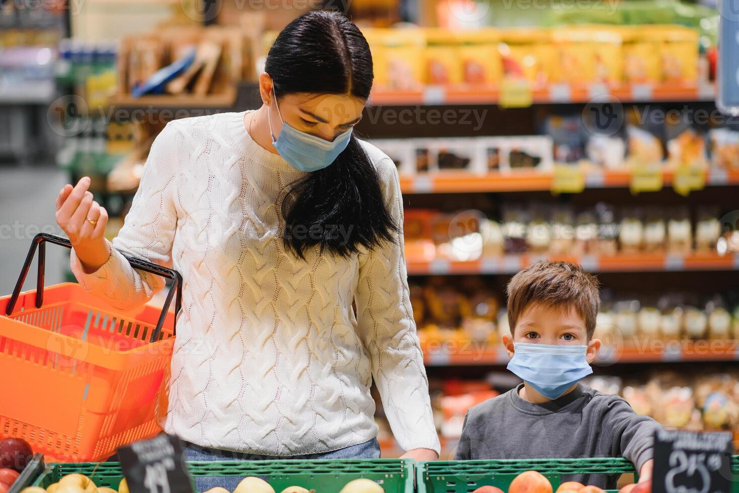 jung Frau und ihr wenig Sohn tragen schützend Gesicht Maske Geschäft ein Essen beim ein Supermarkt während das Coronavirus Epidemie oder Grippe Ausbruch. foto