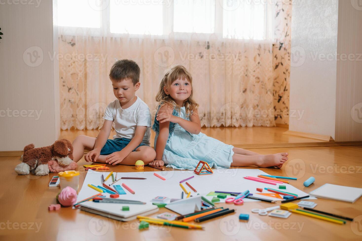 Kinder Zeichnung auf Fußboden auf Papier. Vorschule Junge und Mädchen abspielen auf Fußboden mit lehrreich Spielzeuge - - Blöcke, Zug, Eisenbahn, Ebene. Spielzeuge zum Vorschule und Kindergarten. Kinder beim Zuhause oder Kindertagesstätte foto