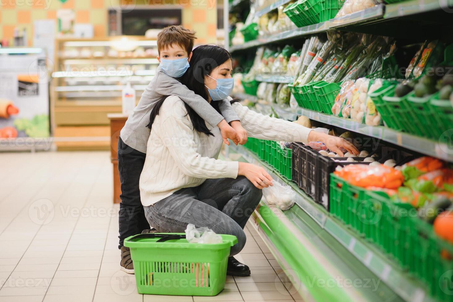 jung Frau und ihr Kind tragen schützend Gesicht Masken Geschäft ein Essen beim ein Supermarkt während das Coronavirus Epidemie oder Grippe Ausbruch. foto