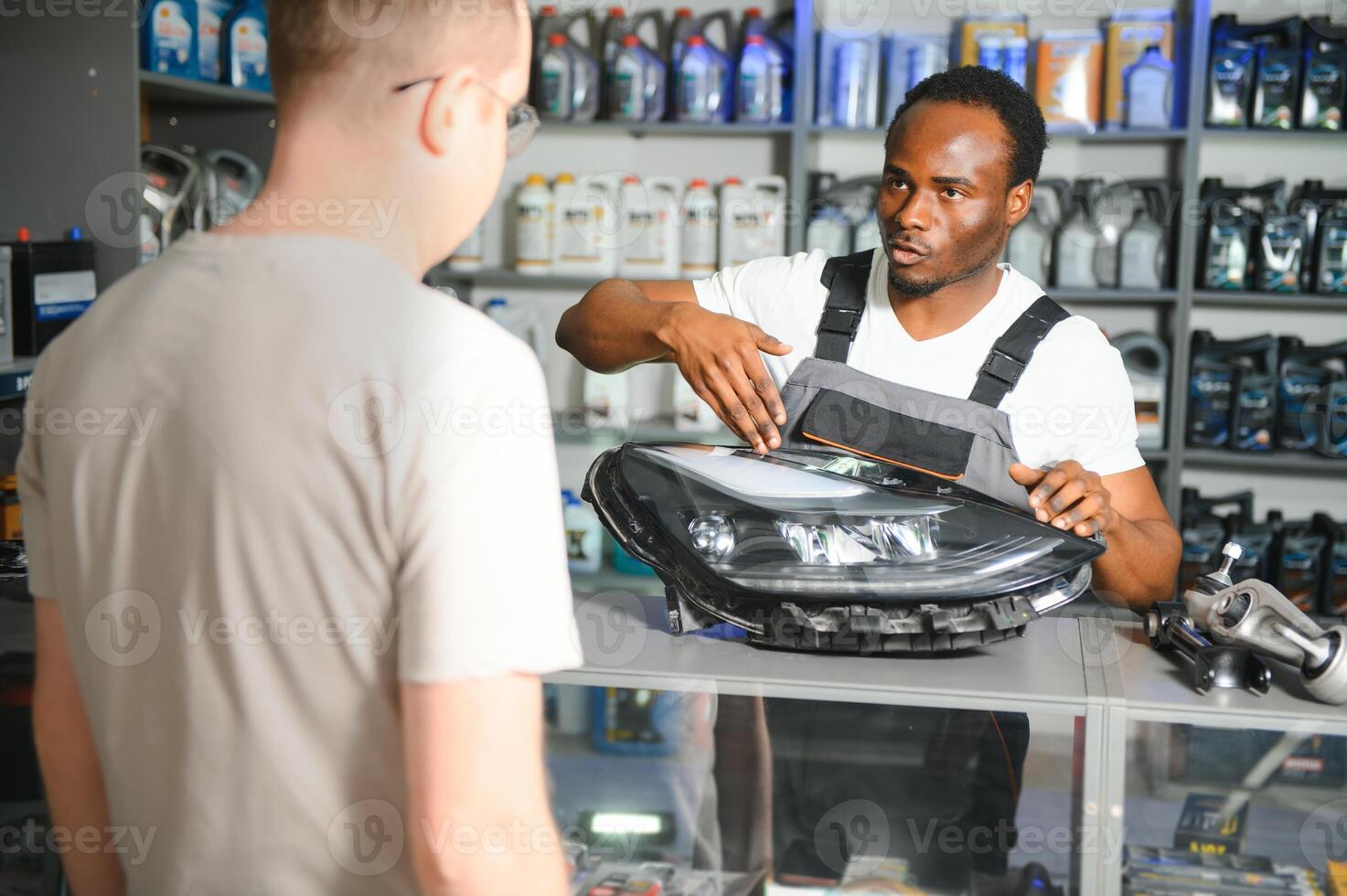 ein Kunde ist reden zu ein Verkäufer beim ein Auto Teile Geschäft foto