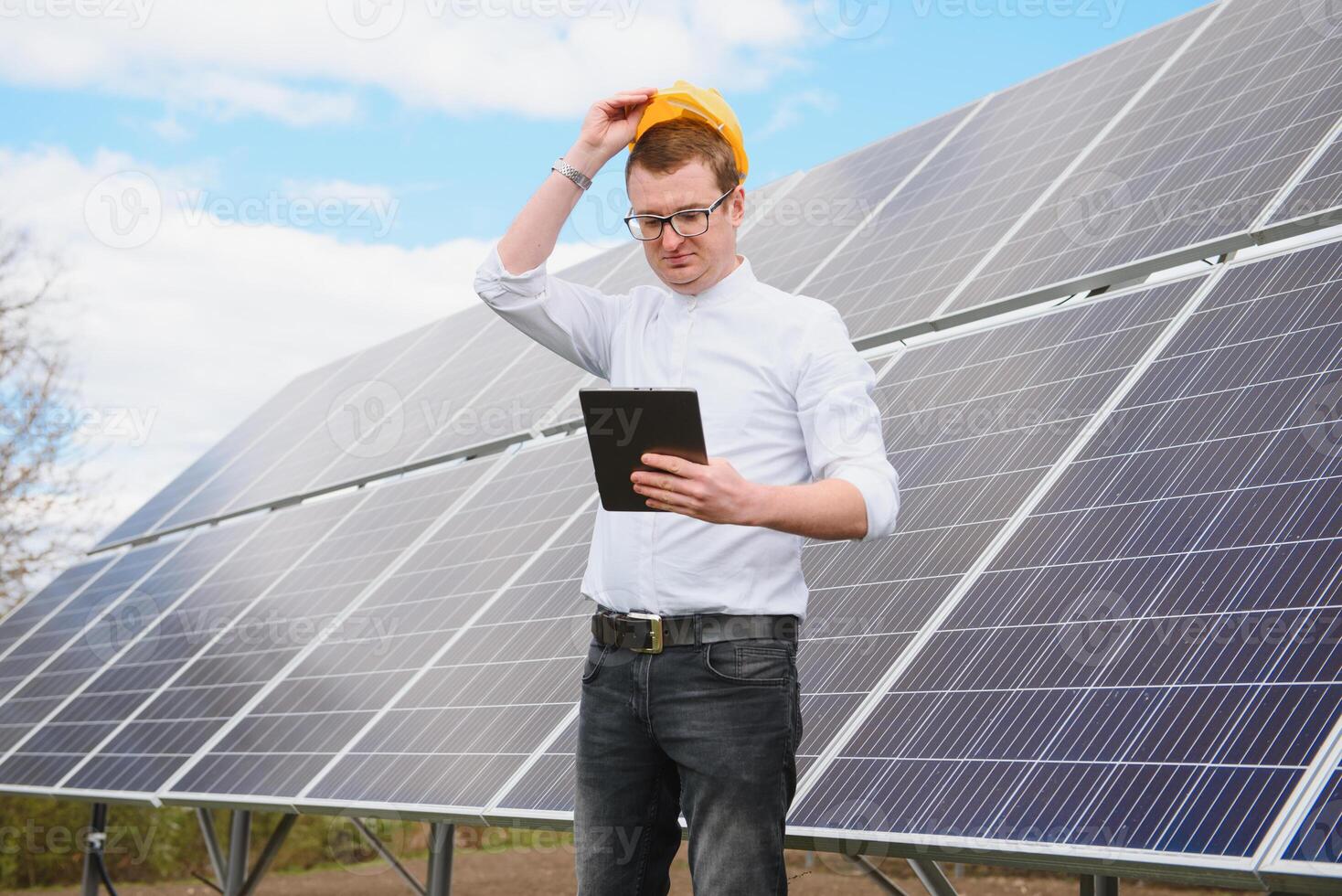 männlich Ingenieur im Helm mit Tablette im Hände Stehen in der Nähe von Solar- Tafeln. Konzept Ökologie Schutz. foto