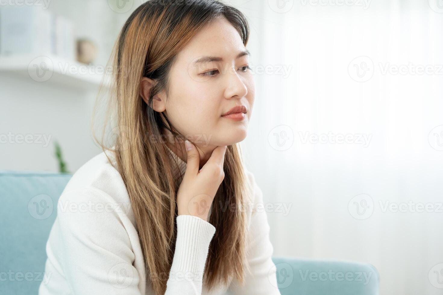 asiatisch Frau stellen ihr Hand auf ihr Hals fällig zu ein wund Kehle. weiblich Mandelentzündung Ursachen ein Entzündung. behandelt durch nehmen Wasser, nehmen Antibiotika, konsultieren ein Arzt, Virus, Corona Virus, Grippe, Grippe foto