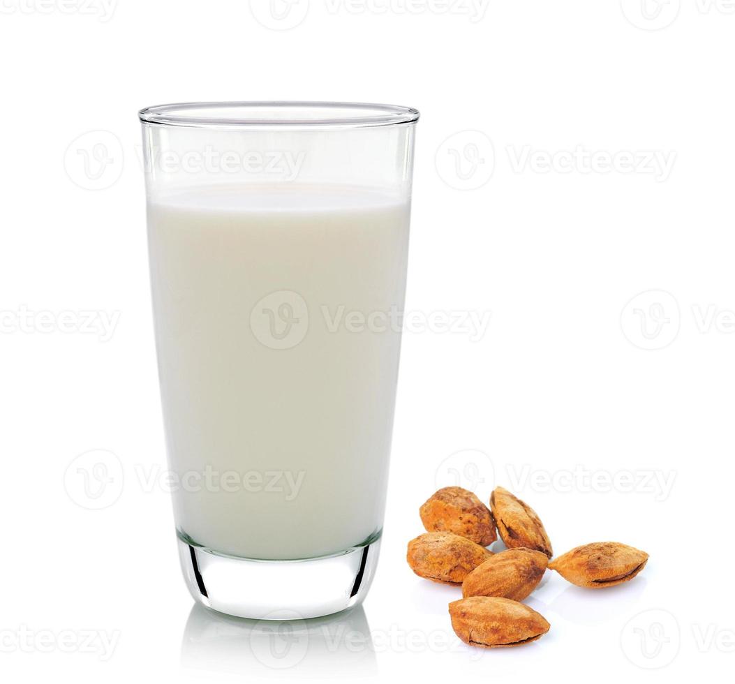 Glas Milch und Mandeln auf weißem Hintergrund foto