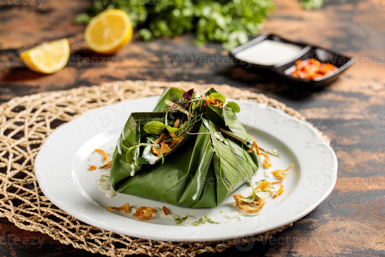 Hähnchen Biryani wickeln im Banane Blatt serviert im Gericht isoliert auf Tabelle oben Aussicht von Arabisch Frühstück foto