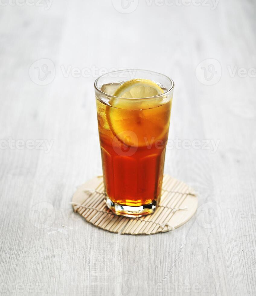 ein Glas von frisch vereist Zitrone Tee mit Zitrone Scheibe isoliert auf grau Hintergrund Seite Aussicht foto