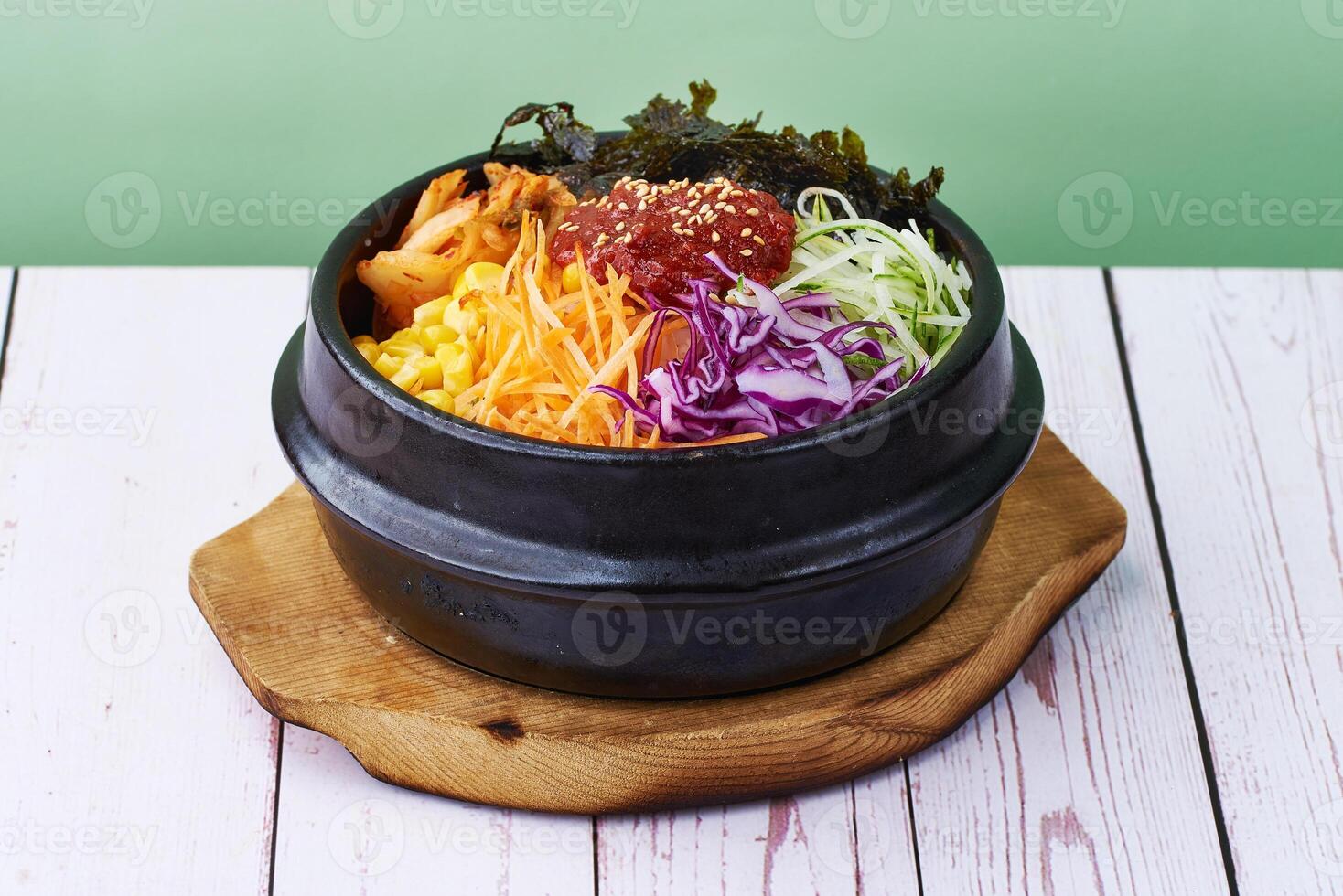 Koreanisch Essen Reis bibimbap mit Gemüse, Rindfleisch und Teriyaki im ein schwarz Schüssel auf Holz Tabelle Hintergrund foto