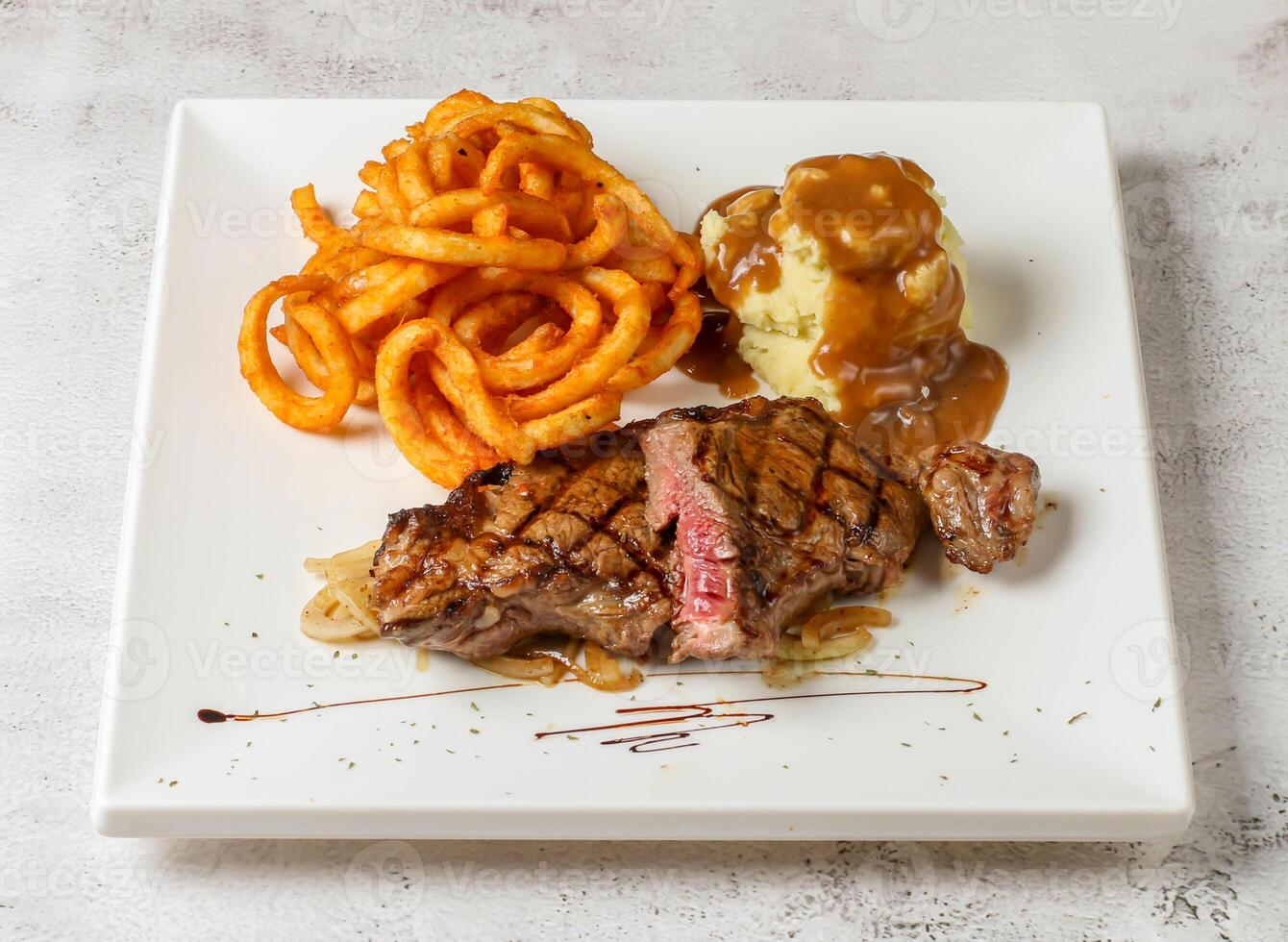 Prime Lendenstück Steak mit lockig Fritten serviert im Gericht isoliert grau Hintergrund oben Aussicht Singapur schnell Essen foto