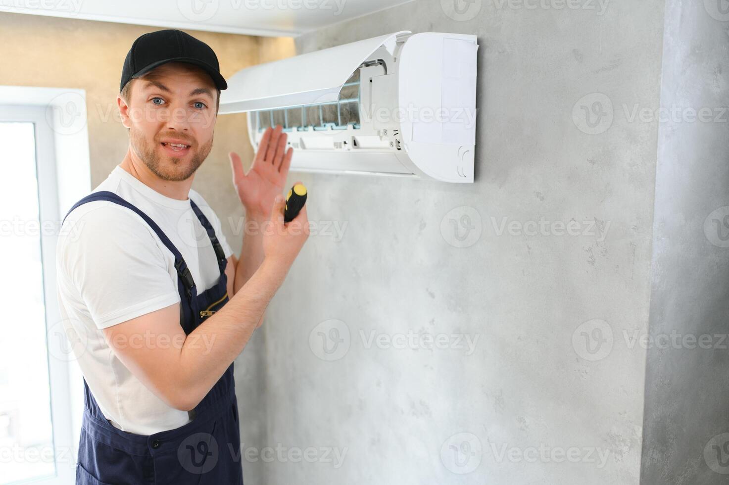 glücklich männlich Techniker reparieren Luft Klimaanlage. foto