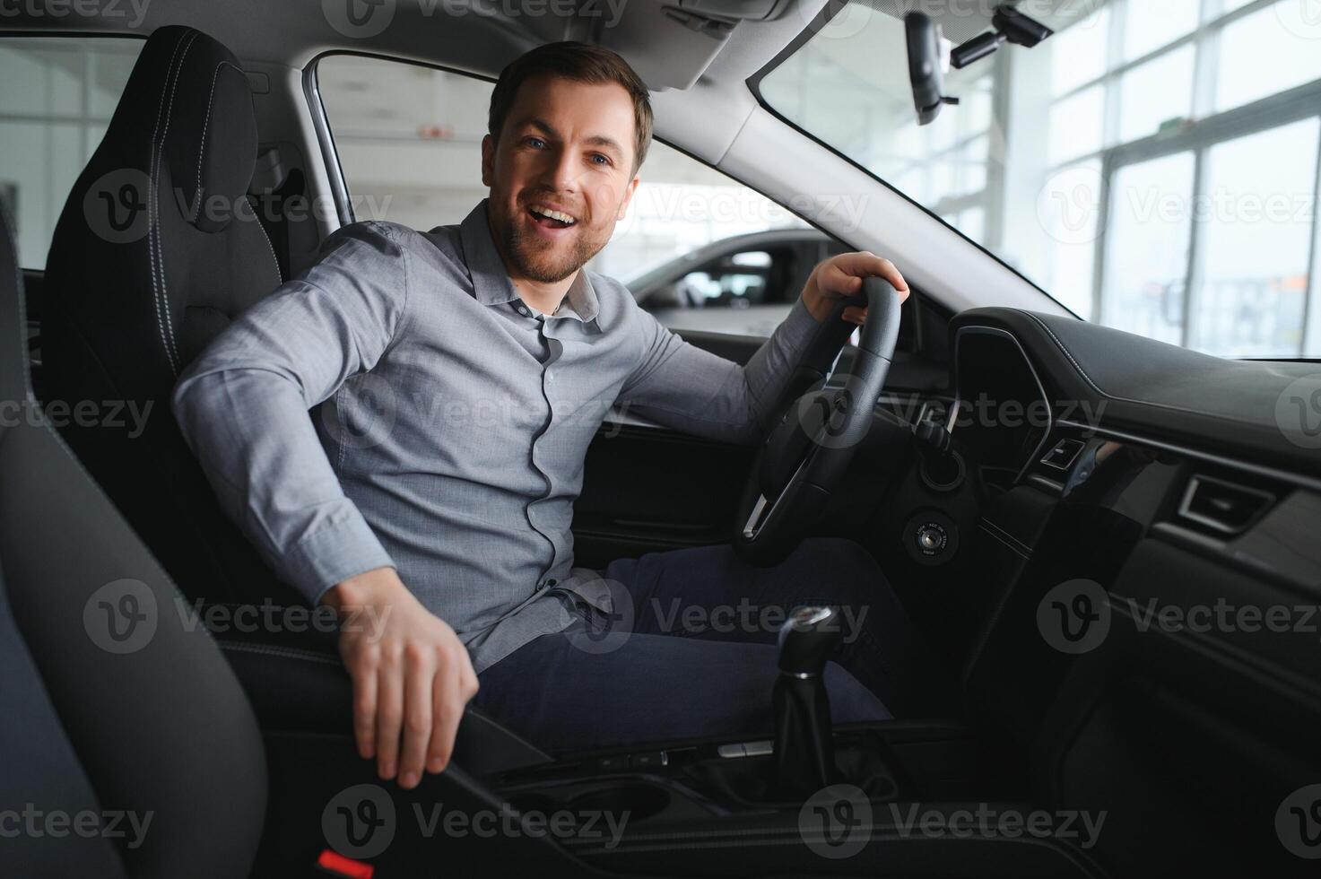 erfolgreich und glücklich. Schuss von ein glücklich reifen Mann lächelnd zu das Kamera Sitzung im seine Marke Neu Auto beim das lokal Händler foto