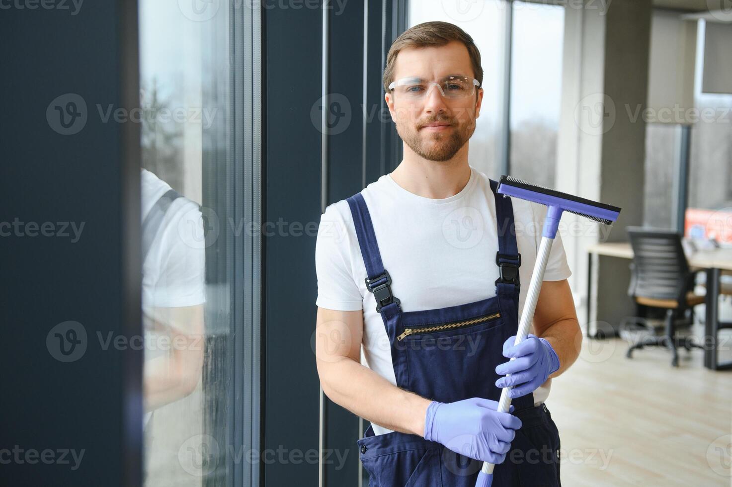 ein Mitarbeiter von ein Fachmann Reinigung Bedienung wäscht das Glas von das Fenster von das Gebäude. Vitrine Reinigung zum Geschäfte und Unternehmen. foto