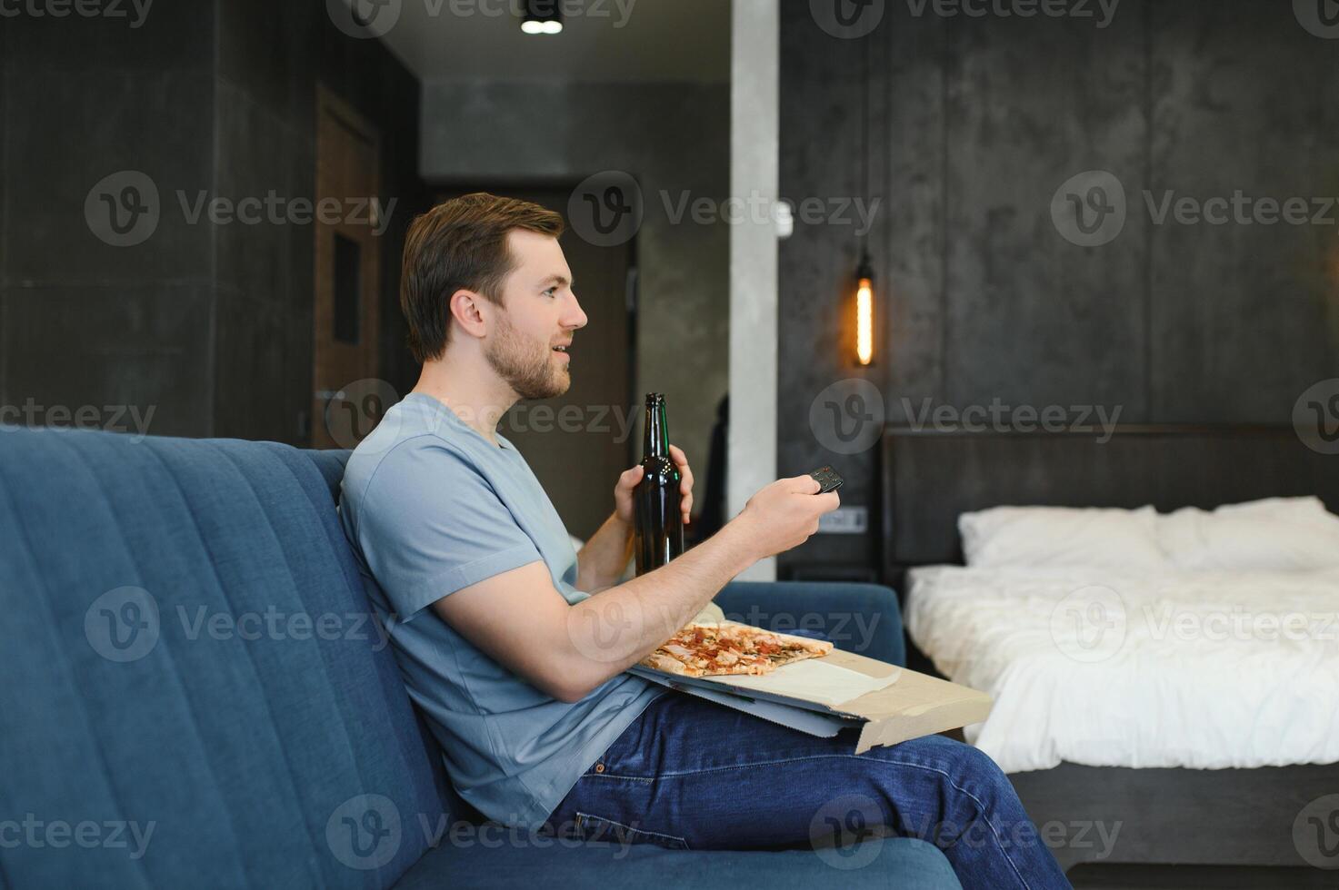 Mann Essen Pizza haben ein wegbringen beim Zuhause entspannend ruhen foto