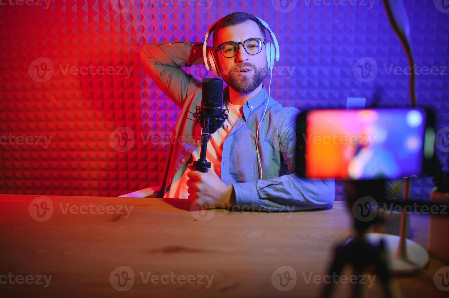 ein Video Blogger Aufzeichnungen Inhalt im seine Studio. das hinter den Kulissen Foto war genommen von hinter einer von das Teilnehmer im das Schießen, beim das Anfang von das Schießen wann das Blogger ist vorbereiten.