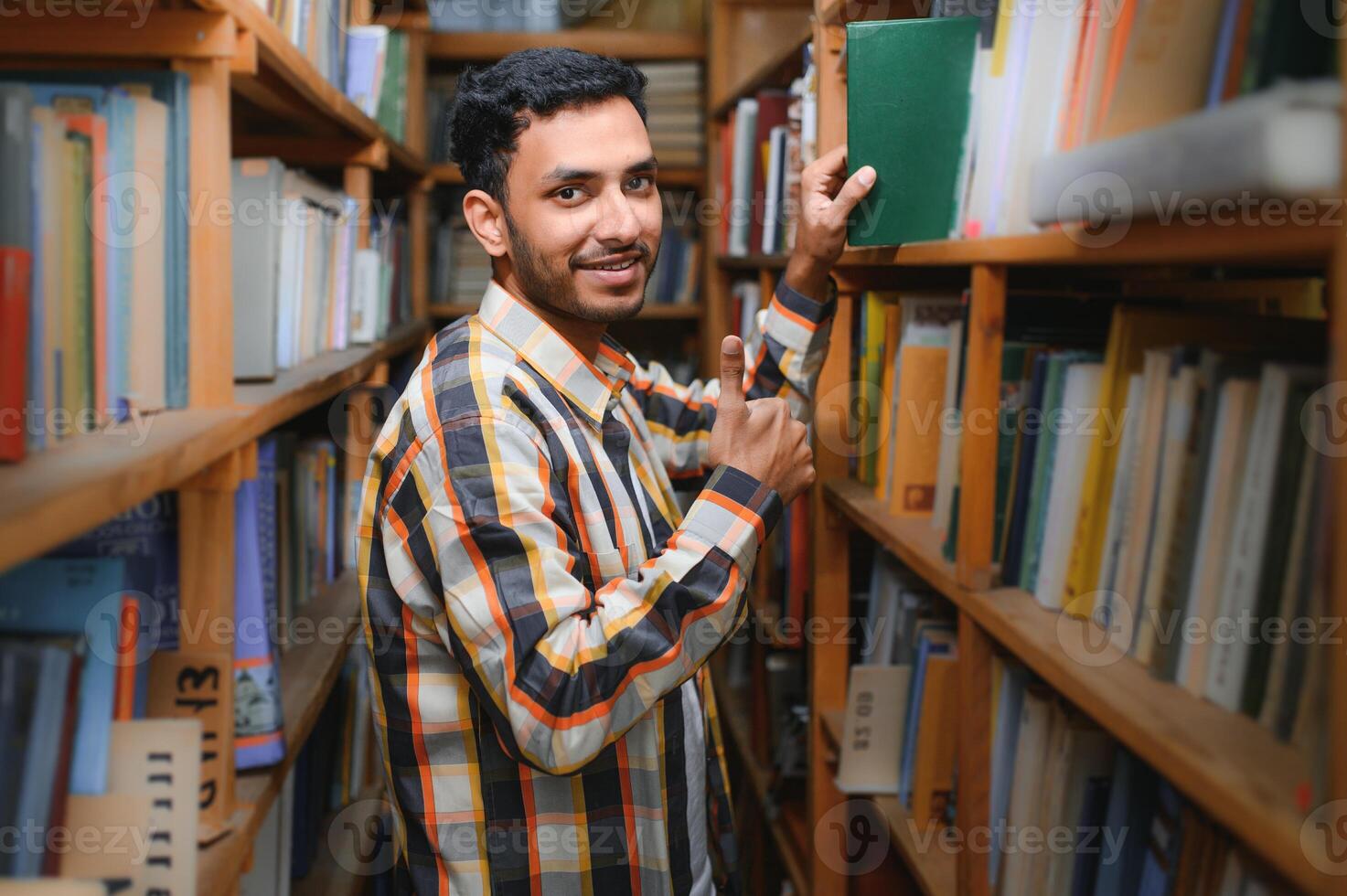 glücklich Clever indisch oder arabisch Kerl, gemischt Rennen männlich, Universität Student, im das Bibliothek foto