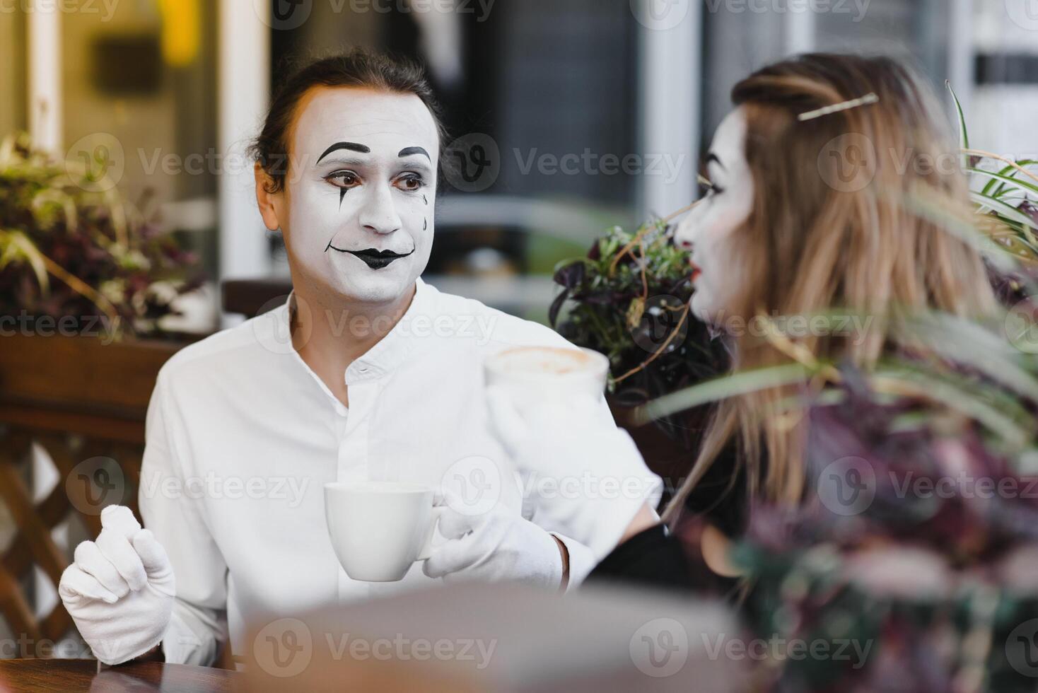 Pantomimen im Vorderseite von Paris Cafe Schauspielkunst mögen Trinken Tee oder Kaffee. foto