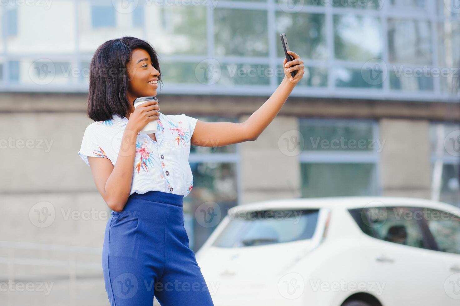 gut suchen afrikanisch weiblich posiert beim Kamera von Zelle Telefon, macht Selfie oder macht Video Anruf foto