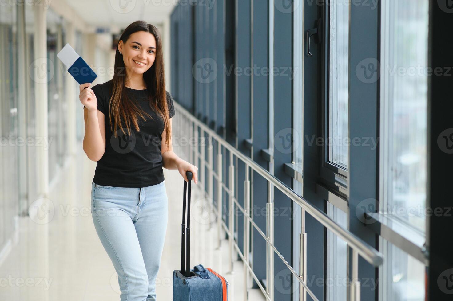 Ferien Reise. schön jung Brünette Dame im Flughafen Terminal, glücklich lächelnd tausendjährig Dame bereit zum Urlaub Reise, gehen zu Abfahrt Tor, Kopieren Raum. foto