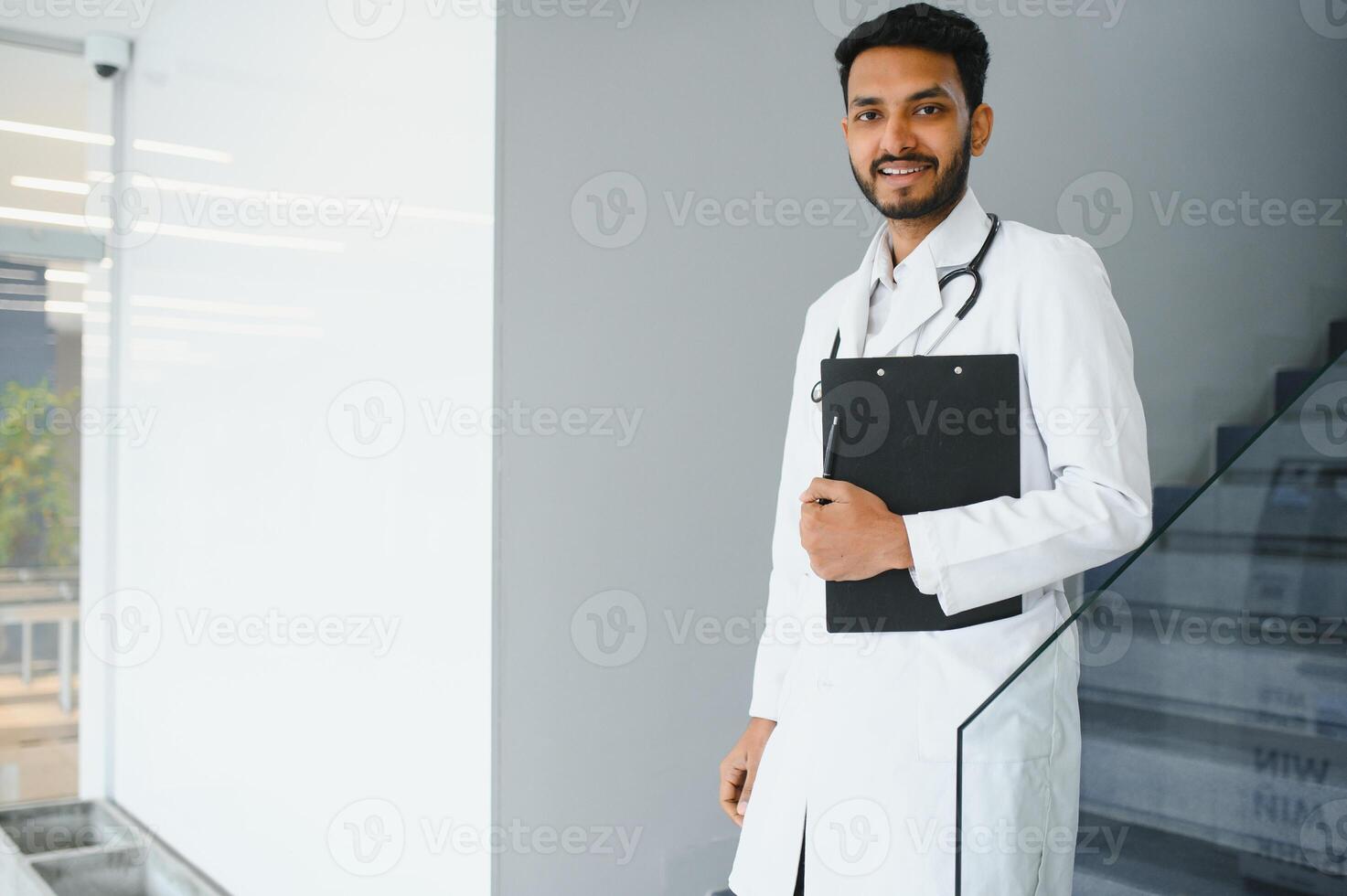 Medizin, Gesundheitswesen und Menschen Konzept - - glücklich männlich Arzt mit Stethoskop und Zwischenablage beim Klinik foto