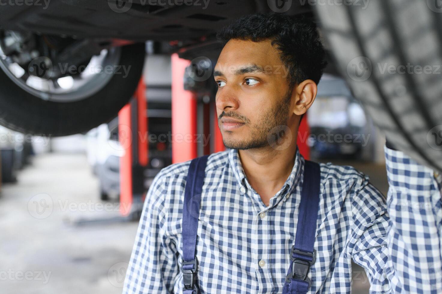 indisch glücklich Auto Mechaniker im Blau Anzug. foto
