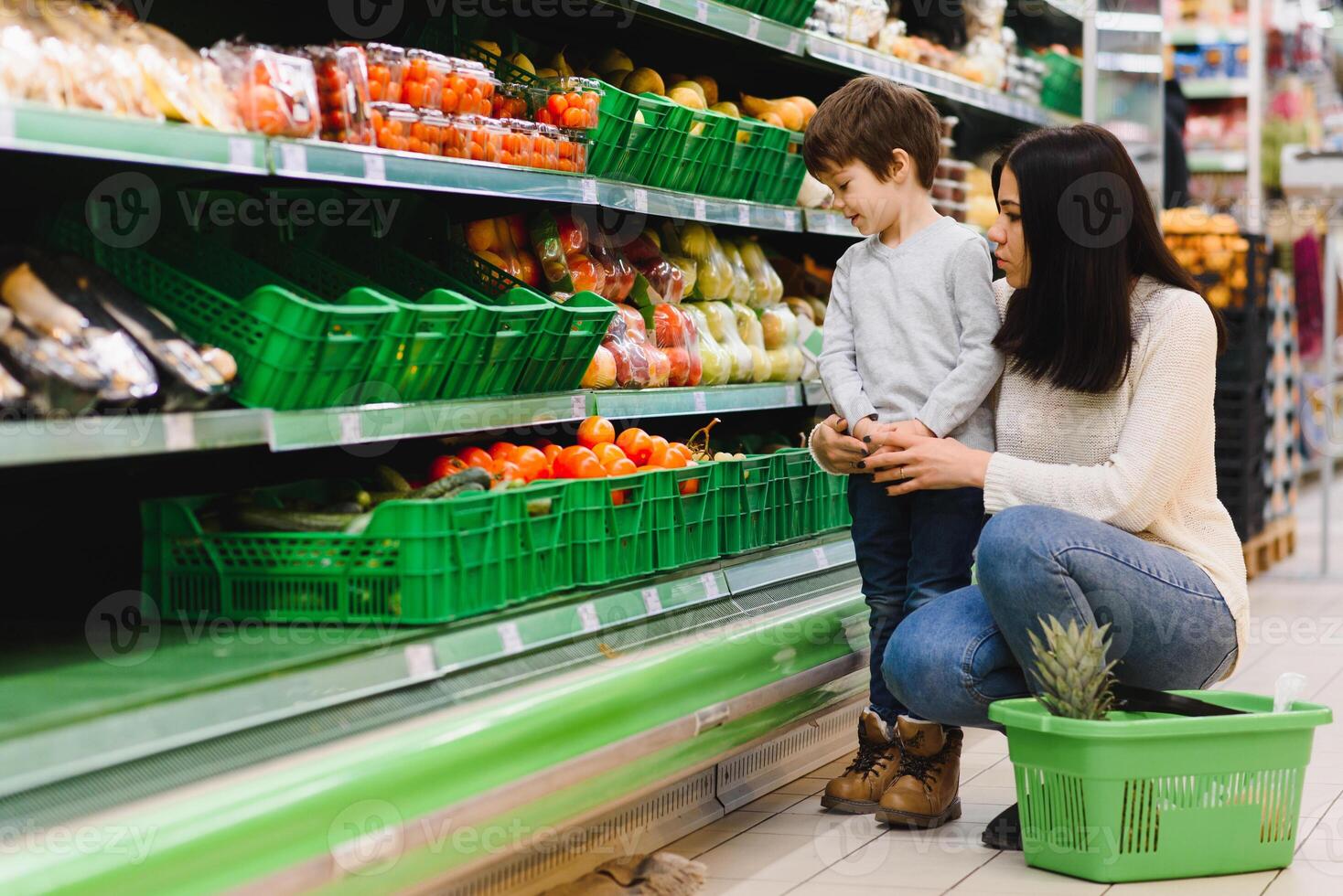 Mutter und ihr Sohn Kauf Früchte beim ein Bauern Markt foto