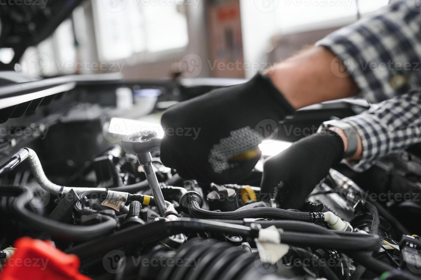 Mechaniker unter der Motorhaube des Autos in der Reparaturwerkstatt foto