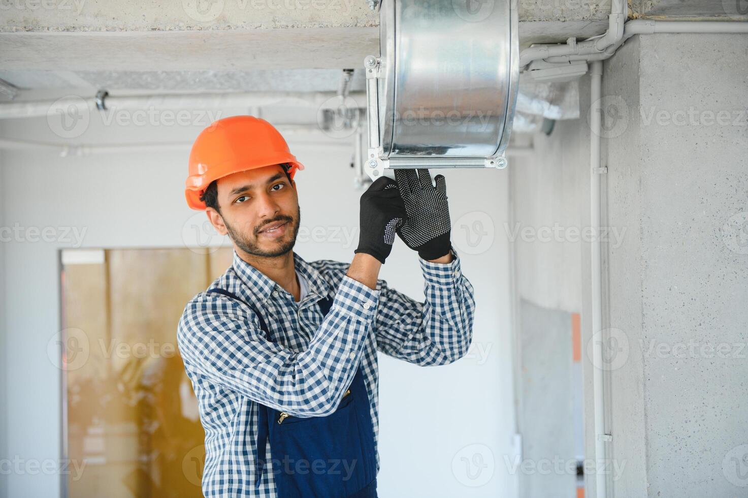 hvac Dienstleistungen - - indisch Arbeiter Installieren geleitet Rohr System zum Belüftung und Luft Konditionierung im Haus foto