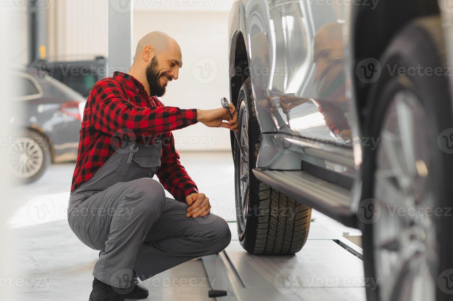 Mechaniker Arbeiten und halten Schlüssel von Bedienung bestellen zum Aufrechterhaltung Auto beim das Reparatur Geschäft foto