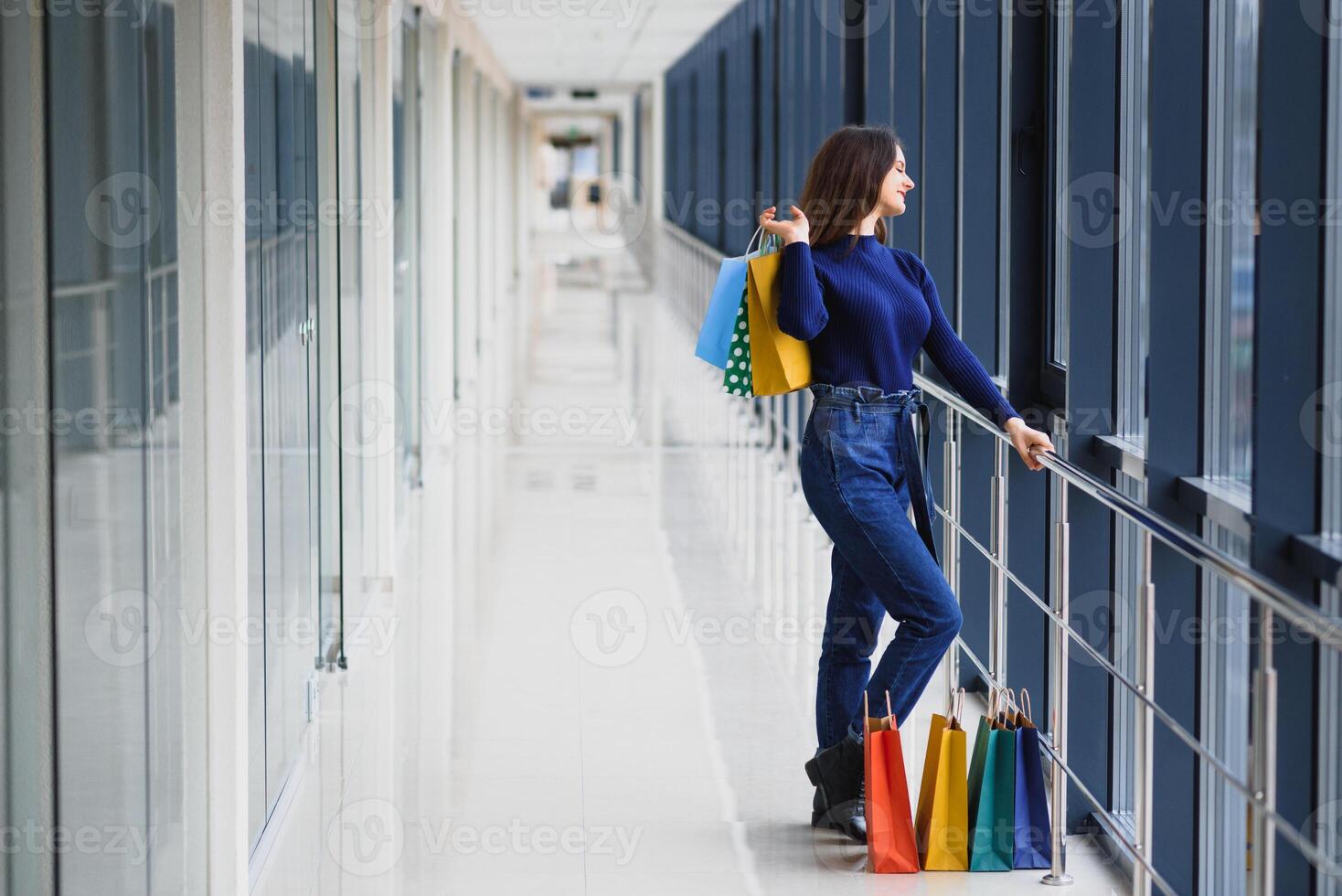 Mode Einkaufen Mädchen Porträt. Schönheit Frau mit Einkaufen Taschen im Einkaufen Einkaufszentrum. Käufer. Verkauf. Einkaufen Center foto