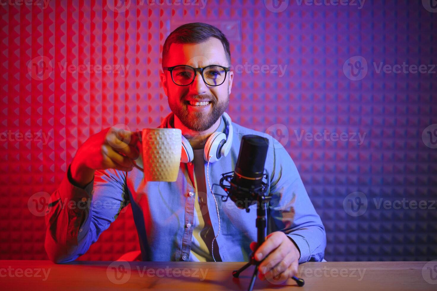 jung Mann Aufzeichnung oder Streaming Podcast mit Mikrofon beim seine klein Übertragung Studio. Inhalt Schöpfer. foto