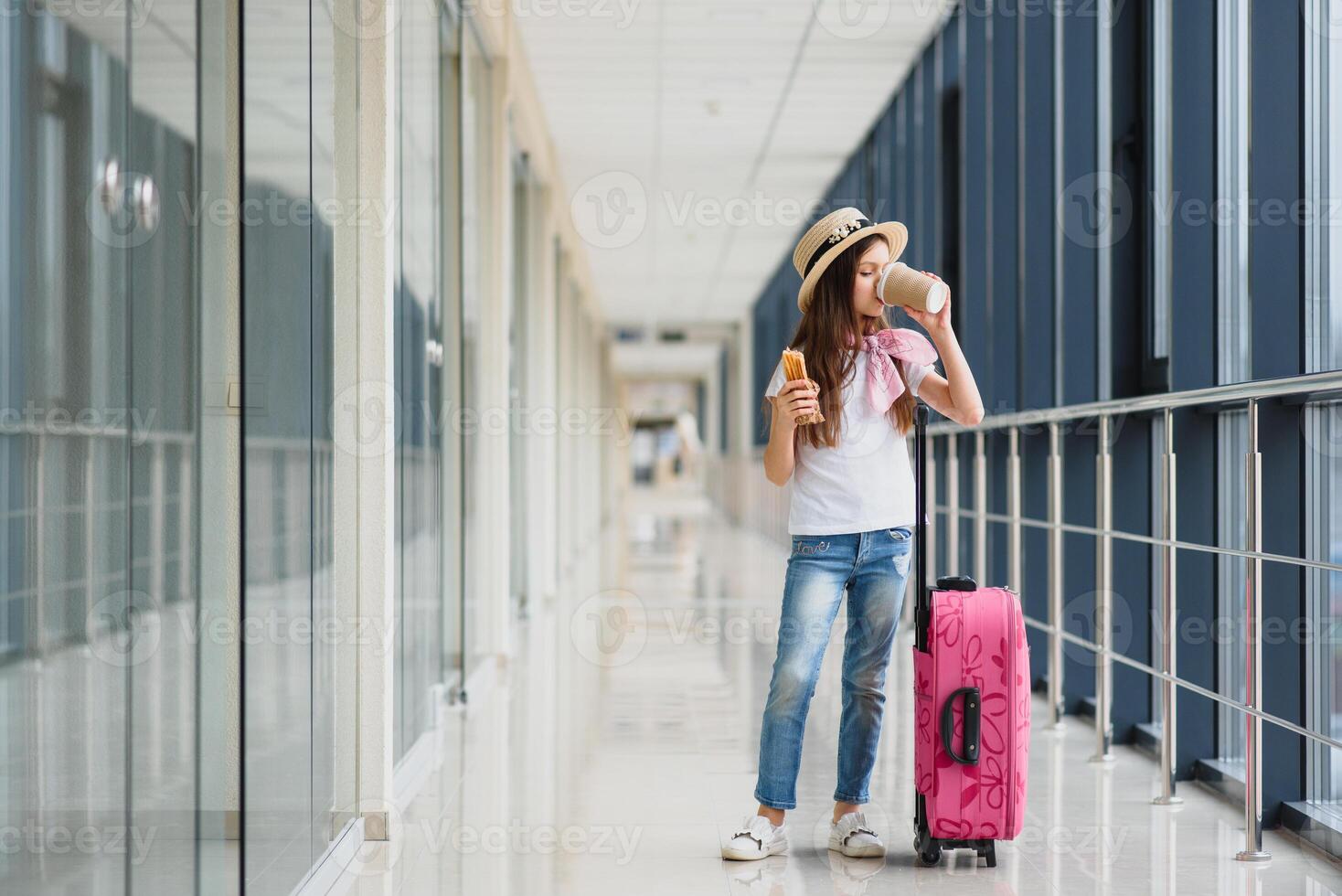 wenig bezaubernd Kind im Flughafen warten zum Einsteigen drinnen. bezaubernd wenig Mädchen beim Flughafen isst schnell Essen und Getränke Tee foto