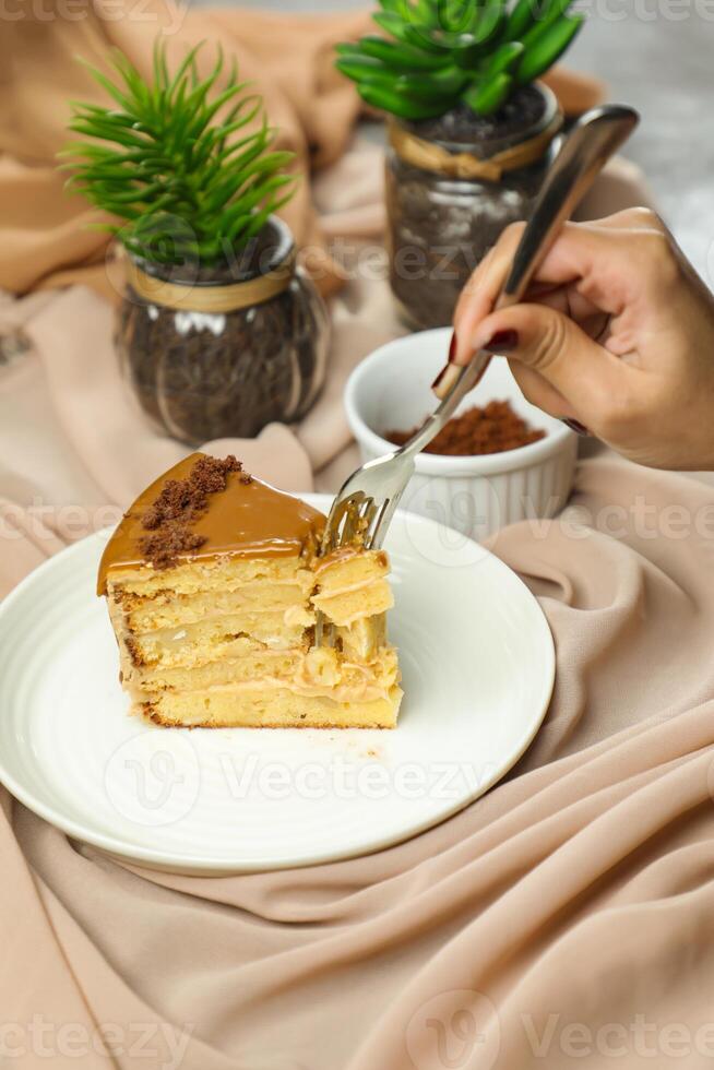 gesalzen Karamell Blondie Kuchen Scheibe umfassen Schokolade Creme, Zucker mit Gabel, Tasse von Kaffee und Topf serviert Teller isoliert auf Serviette Seite Aussicht von Cafe Essen foto