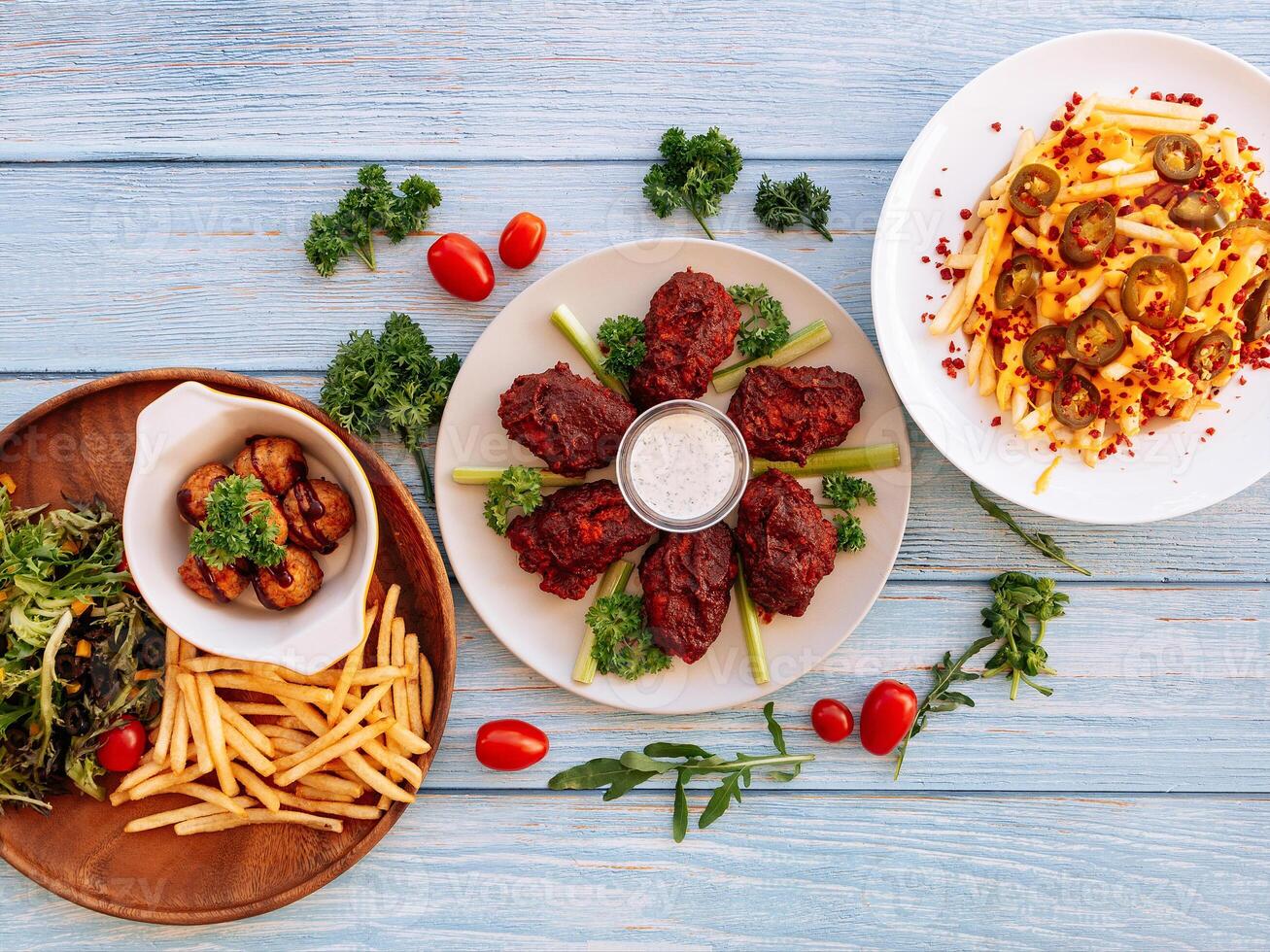 sortiert Fast Food Büffel Mitte Joint Flügel, geladen käsig Fritten, Fleischklößchen mit Chips serviert im Gericht isoliert auf hölzern Tabelle oben Aussicht Fast Food foto