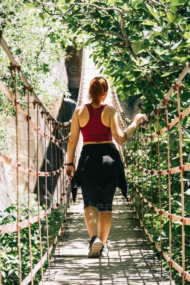 junge Frau auf einer Hängebrücke zu Fuß auf der Route Los Cahorros, Granada, Spanien? foto