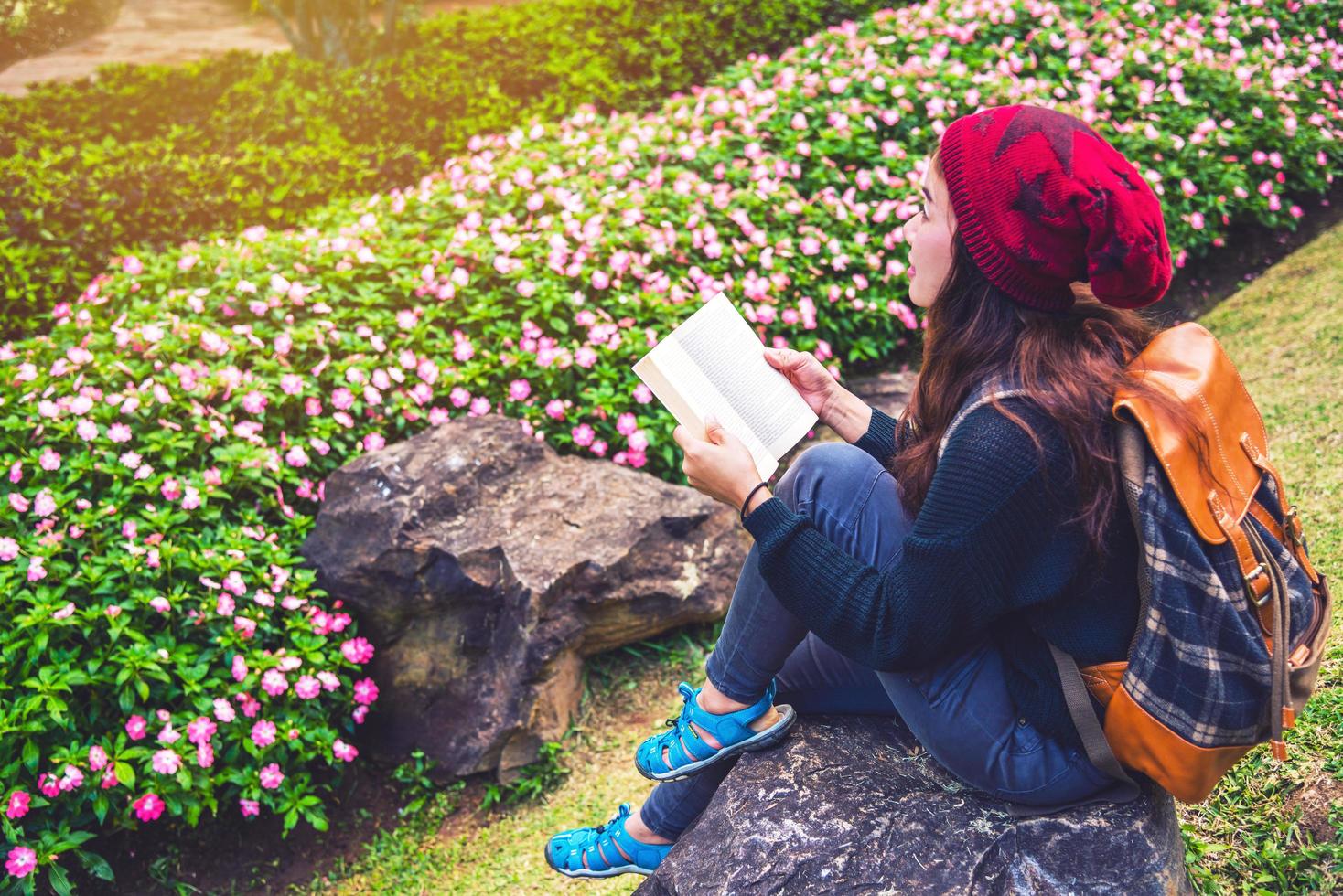 Frau reisen Natur im Blumengarten. Entspannen Sie auf Felsen sitzen und Bücher lesen inmitten der Natur im Nationalpark Doi Inthanon. foto