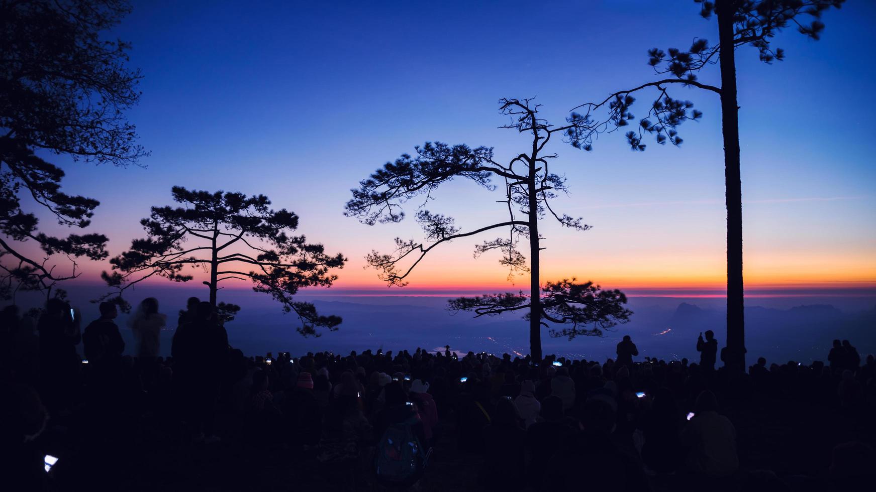 Menschen, die morgens den Sonnenaufgang beobachten. Touristen reisen im Urlaub entspannen. Fotografieren Sie den Sonnenaufgang am Morgen unter Menschen. Thailand foto