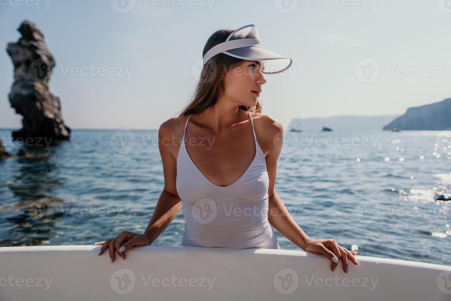 Frau Meer sup. schließen oben Porträt von glücklich jung kaukasisch Frau mit lange Haar suchen beim Kamera und lächelnd. süß Frau Porträt im ein Weiß Bikini posieren auf sup Tafel im das Meer foto