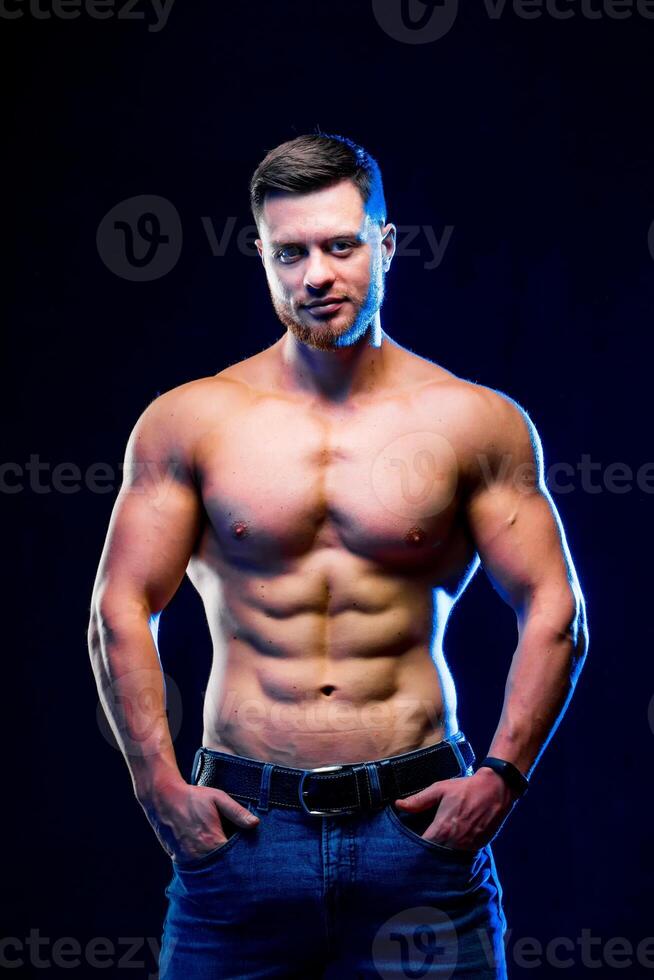 Nahansicht von ein gut aussehend Leistung sportlich Mann Bodybuilder. Fitness muskulös Körper auf dunkel Hintergrund. Nahansicht foto