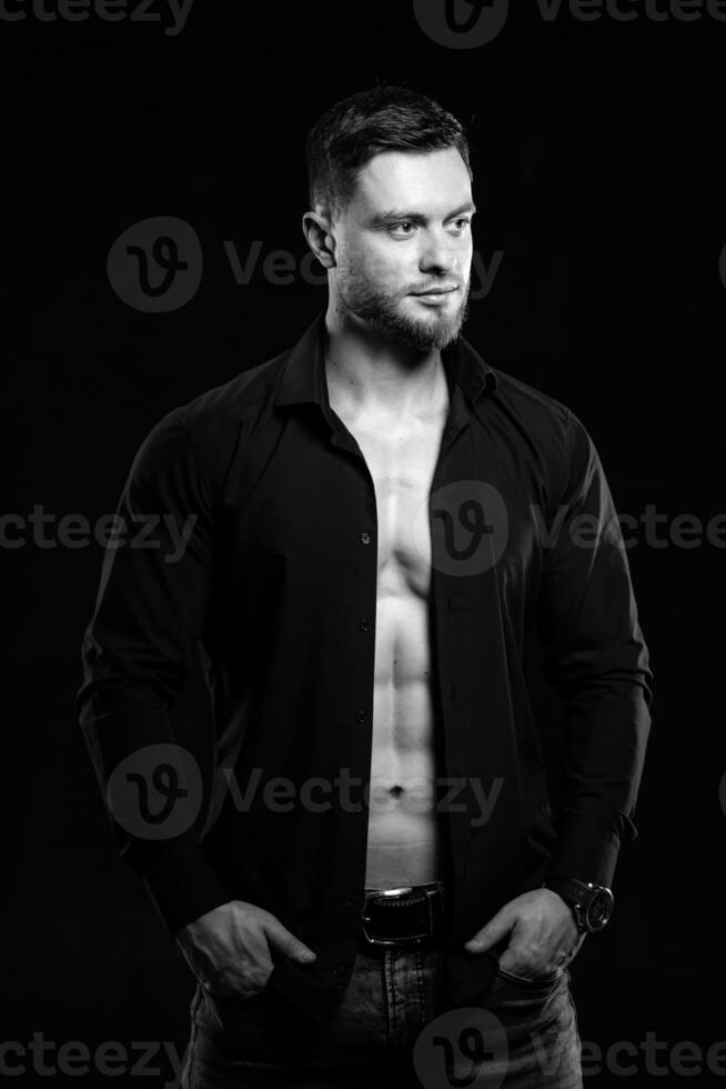 muskulös jung Mann auf dunkel Hintergrund im fark aufgeknöpft Shirt. Nahaufnahme. schwarz und Weiß. foto