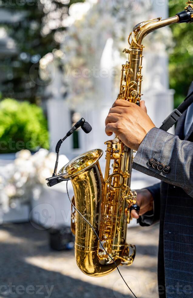 Hände von Mann spielen Saxophon. schließen oben Aussicht von das Hände von ein männlich Saxophonist spielen ein Tenor Saxophon. Jazz, klassisch und Blues Musik- beim Hochzeit. foto