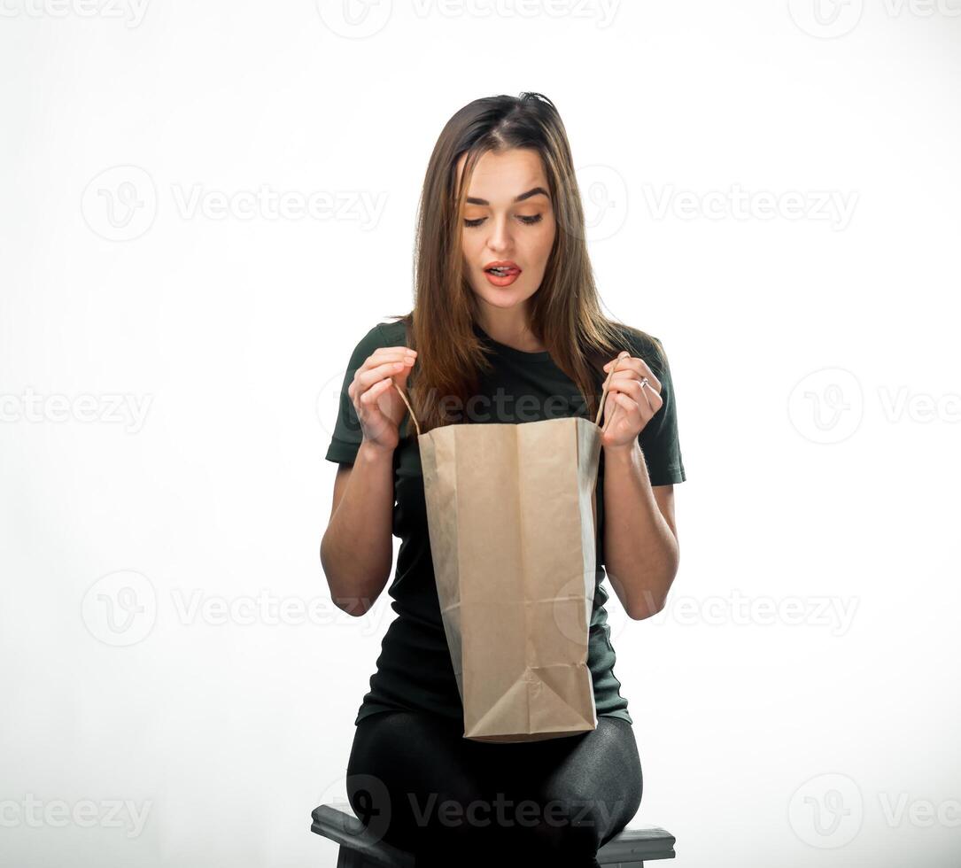 Frau mit ein schön Lächeln ist suchen zu das Lebensmittelgeschäft Tasche. isoliert Hintergrund. schließen hoch. foto