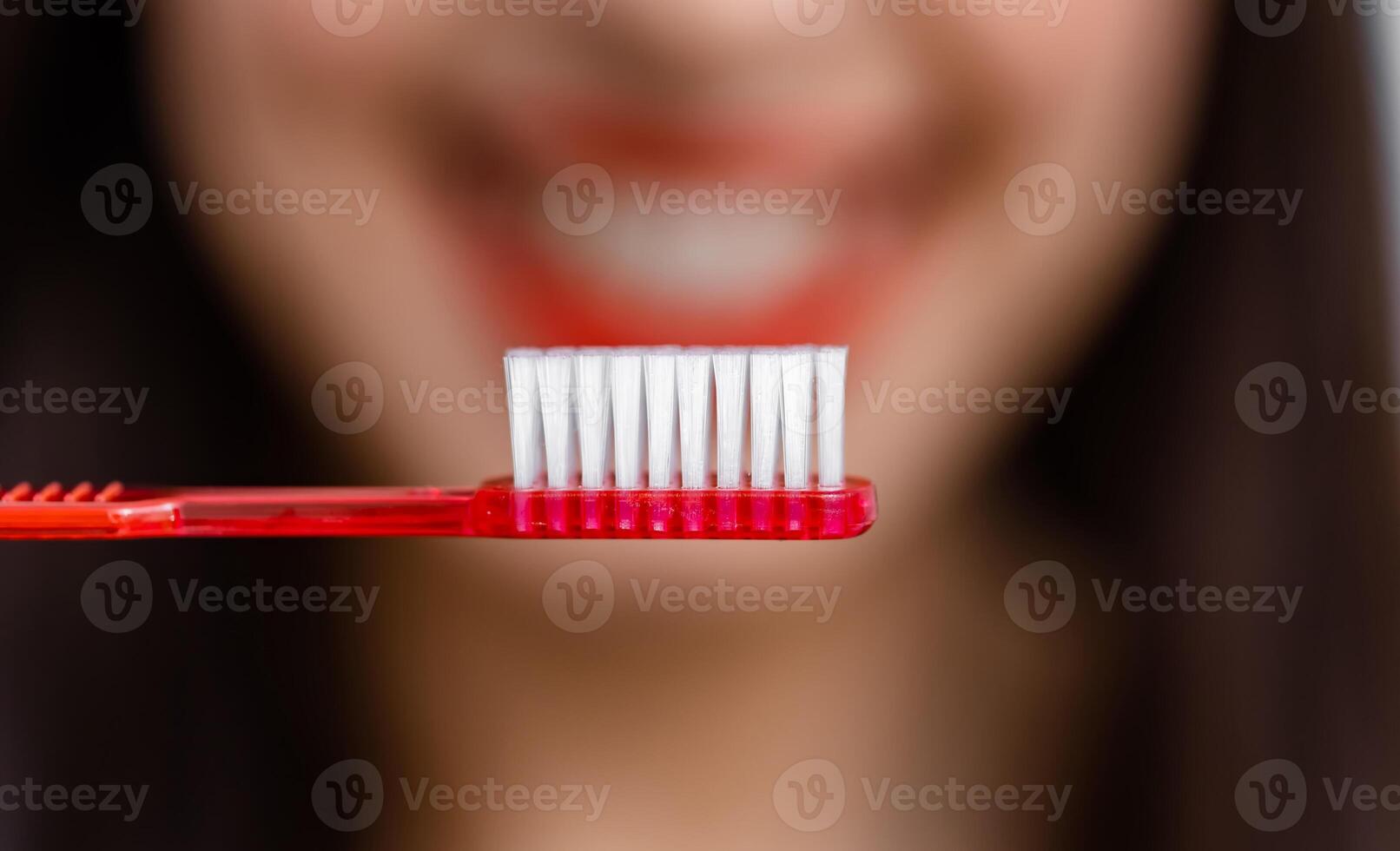 lächelnd jung Frau mit gesund Zähne hält ein Zahnbürste. selektiv Fokus. abgeschnitten Foto. verschwommen Hintergrund. foto