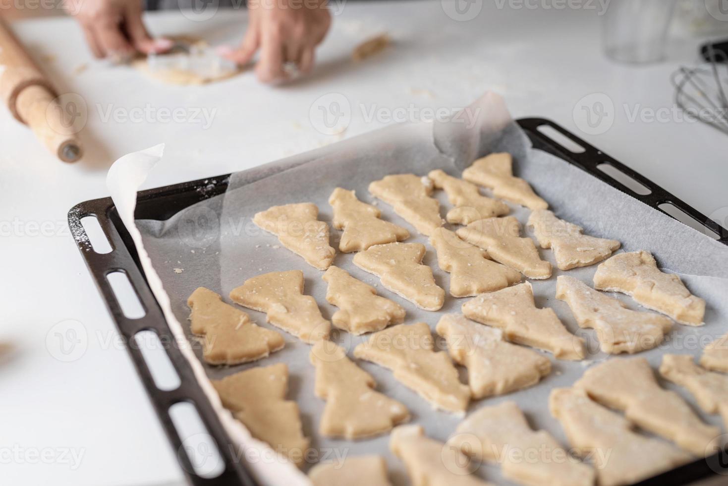 lächelnde Frau in der Küche, die Weihnachtsplätzchen backt foto