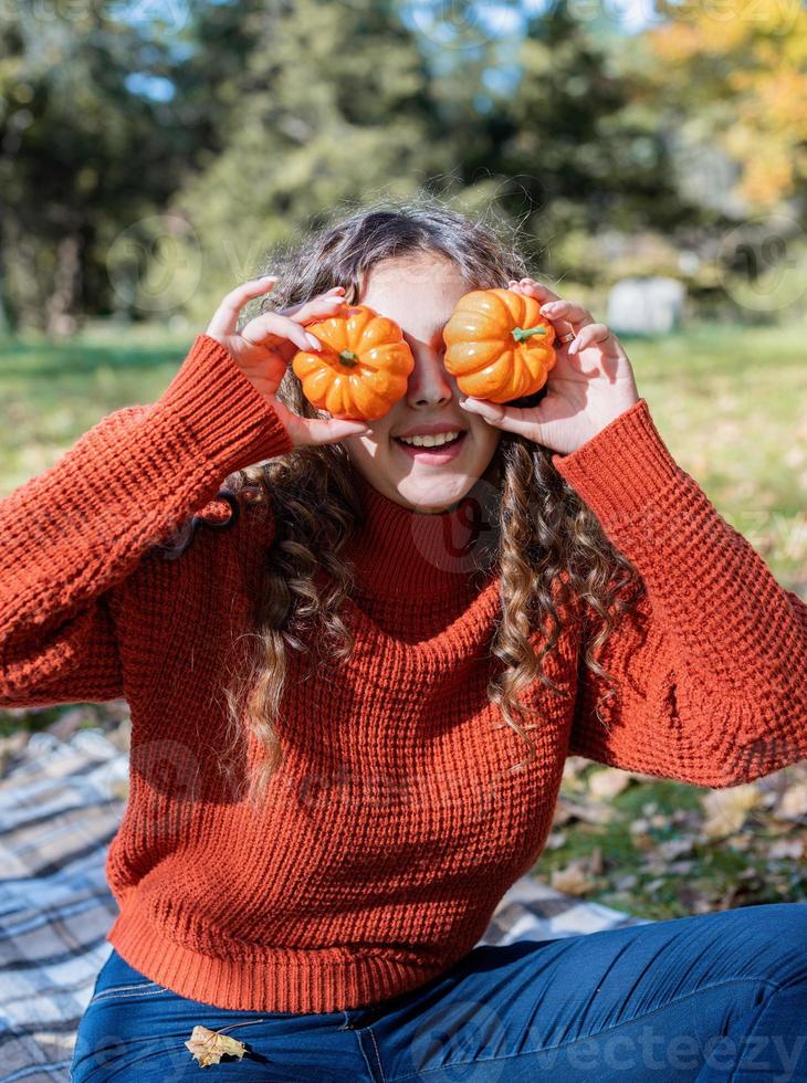 schöne Frau im roten Pullover bei einem Picknick in einem herbstlichen Wald foto