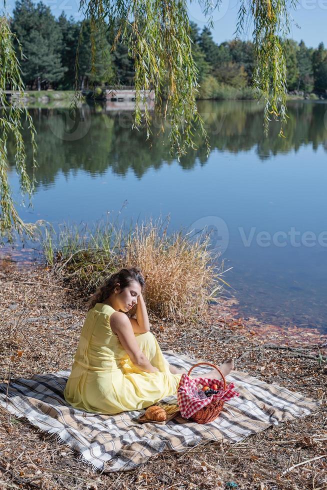 schöne Frau im gelben Kleid bei einem Picknick foto