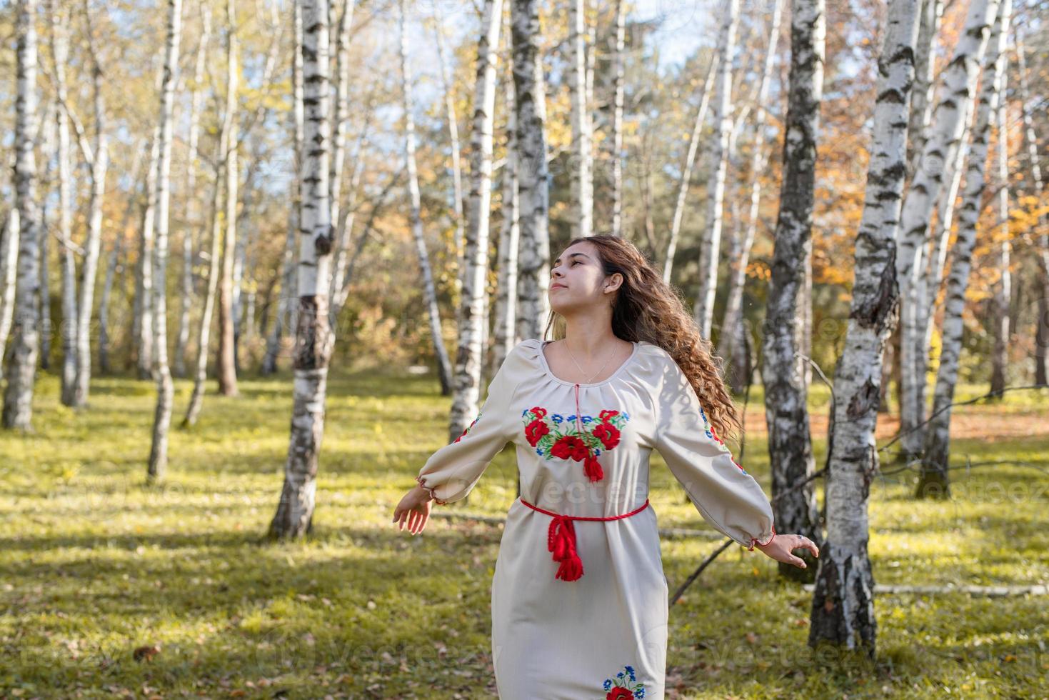 schöne Frau in ukrainischer Tracht, die im Wald tanzt foto