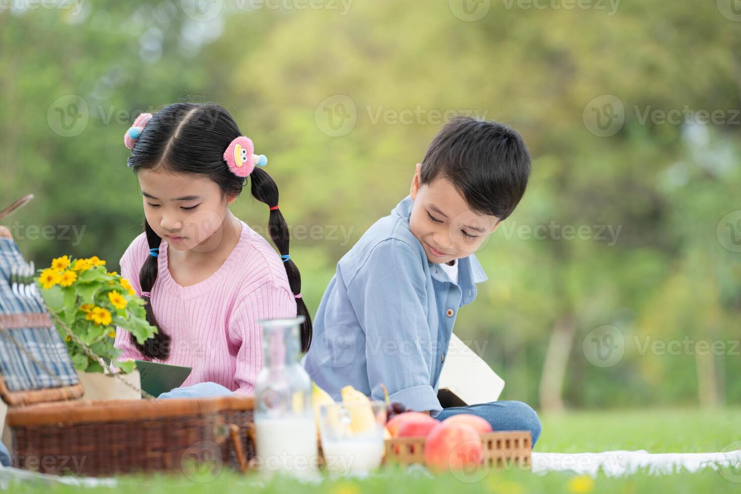 glücklich Familie genießen ein Picknick im das Park, Kinder Sitzung zurück zu zurück und lesen Bücher. foto