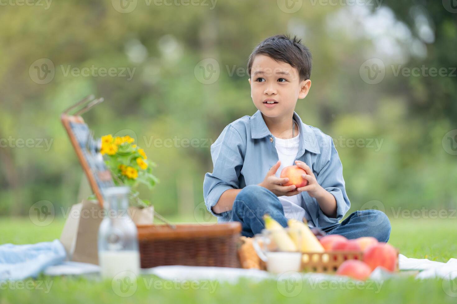 glücklich Familie genießen ein Picknick im das Park, mit Kinder haben Spaß Sitzung, umgeben durch Natur foto