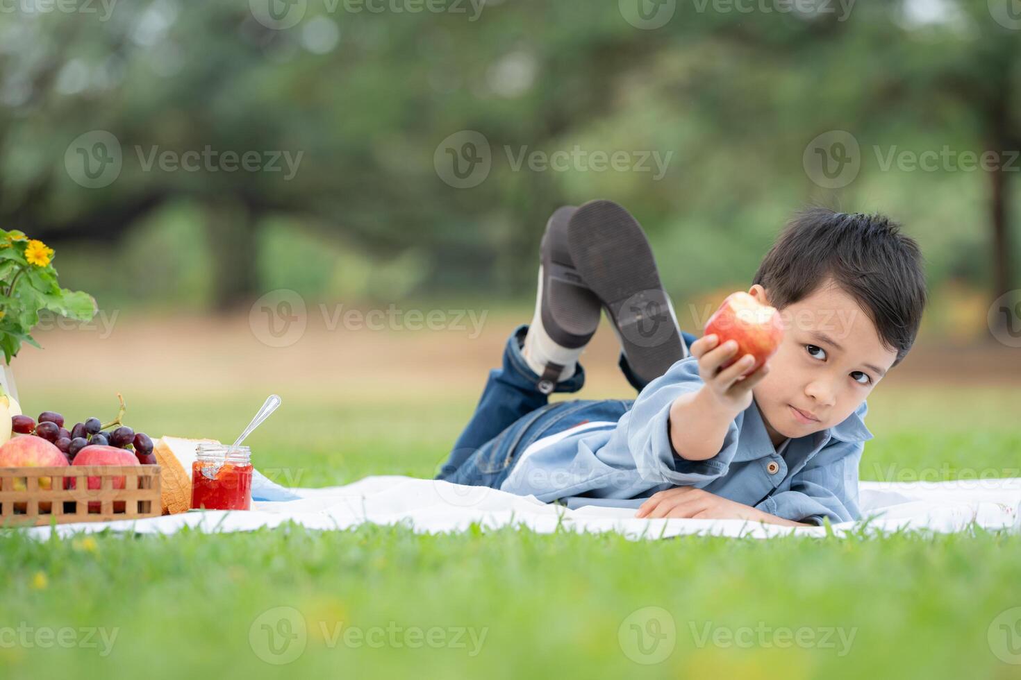 glücklich Familie genießen ein Picknick im das Park, mit Kinder haben Spaß Sitzung, umgeben durch Natur foto