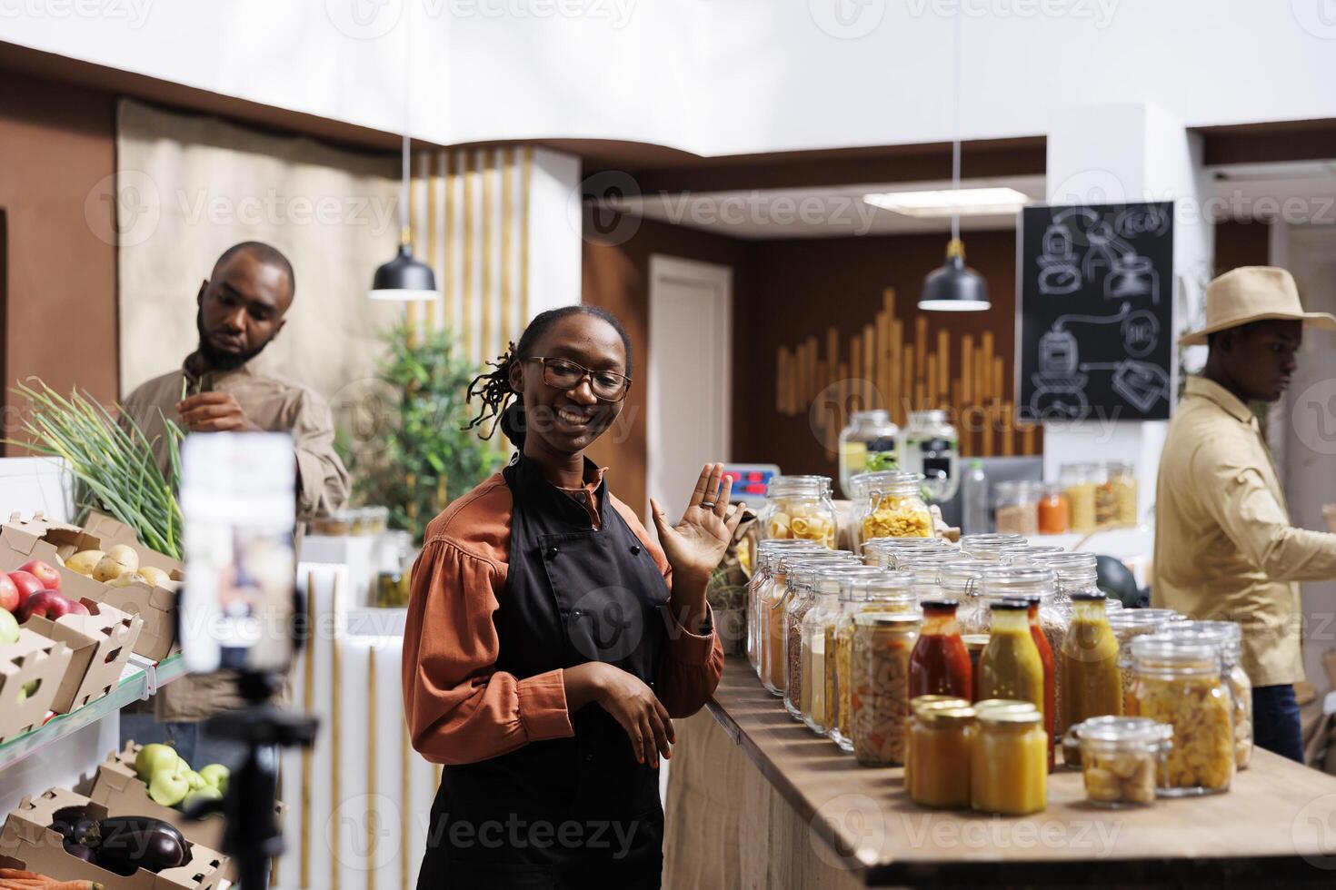 afrikanisch amerikanisch Geschäft Inhaber fördern frisch, organisch Produkte im ein modern, Öko freundlich speichern. Kunden Durchsuche und Kaufen während Erfassen Beachtung durch Sozial Medien und online Marketing. foto